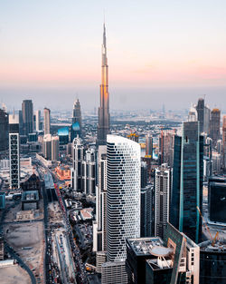 Aerial view of buildings in city at sunset