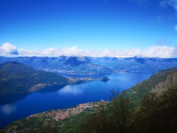 Scenic view of lake and mountains against blue sky