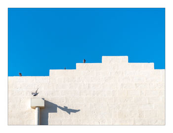 Low angle view of building against clear blue sky