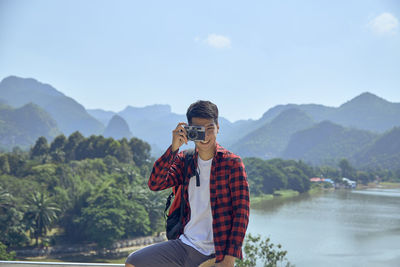 Man wearing sunglasses on mountain against sky