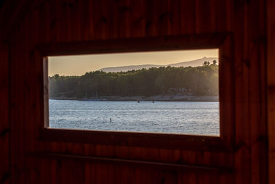 Scenic view of sea against sky seen through window