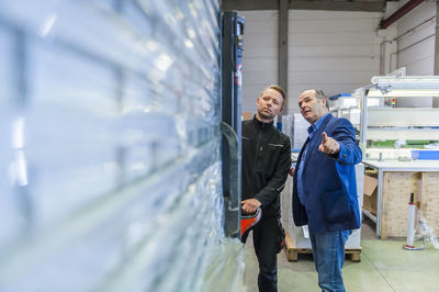 Manager and warehouseman dicussing logistics in storage