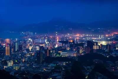 High angle view of illuminated buildings against sky at night