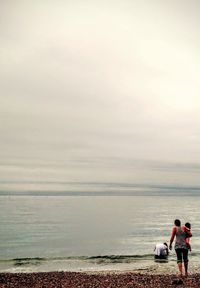 Rear view of woman with child on the beach