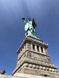 Low angle view of statue against blue sky