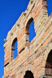 Low angle view of old ruin building against blue sky