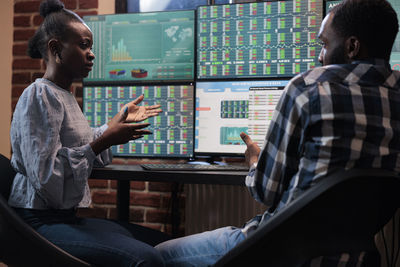 Business colleagues analyzing graph on computer