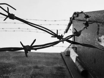 Low angle view of barbed wire against clear sky