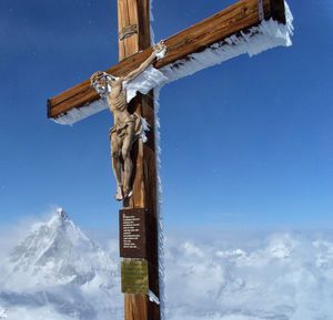Low angle view of crucifix against blue sky