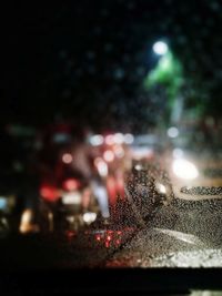 Close-up of wet car on road at night