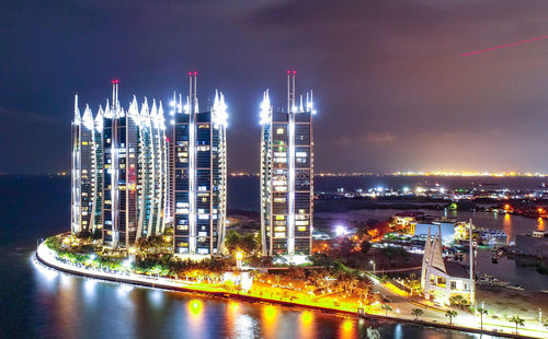 High angle view of illuminated buildings against sky at night