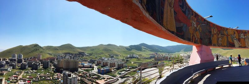 Panoramic view of city buildings against clear blue sky