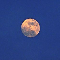 Low angle view of moon against blue sky