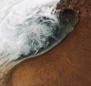 High angle view of waves splashing on rock
