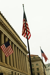 Low angle view of flag flags against sky