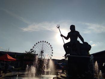 Silhouette of man with arms raised against sky