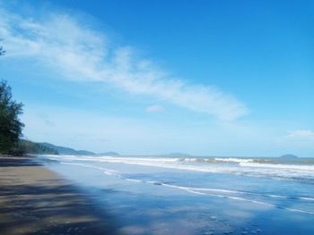 Scenic view of beach against blue sky