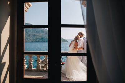 Couple standing by window