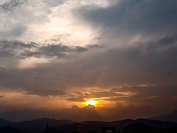 Low angle view of silhouette mountains against dramatic sky