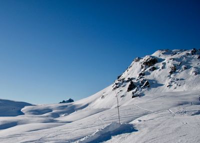 Scenic view of snow mountains against clear blue sky