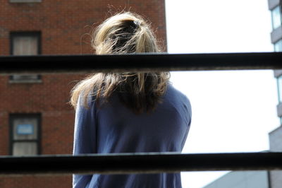 Rear view of woman seen through window