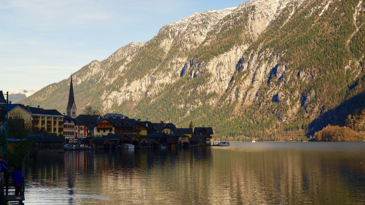 water, mountain, built structure, reflection, outdoors, sky, waterfront, architecture, day, building exterior, tranquility, nature, scenics, no people, mountain range, sea, beauty in nature