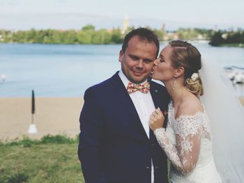 Happy couple standing in front of sea