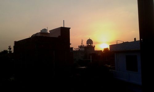 Silhouette buildings against sky during sunset