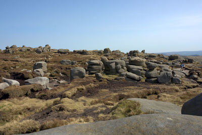 Stone wall by sea against clear sky