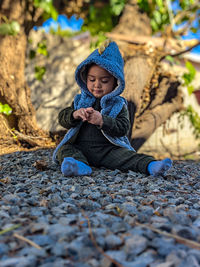 Portrait of young woman sitting on field