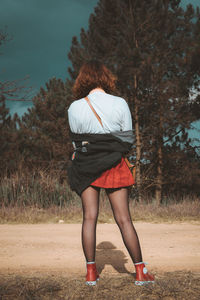 Rear view of woman standing on field