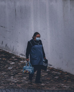 Rear view of woman with umbrella walking on wall