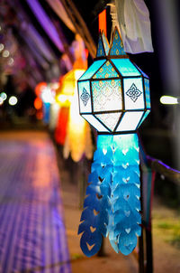 Close-up of illuminated lighting equipment hanging at night