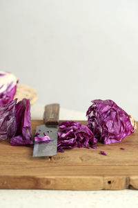 Fresh cut sliced raw purple red cabbage on wooden chopping board with knife, copy space for text