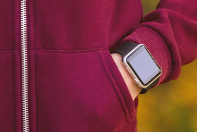 Midsection of woman wearing warm clothing and wristwatch