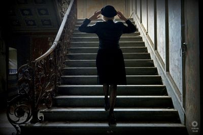 Rear view of woman standing on staircase