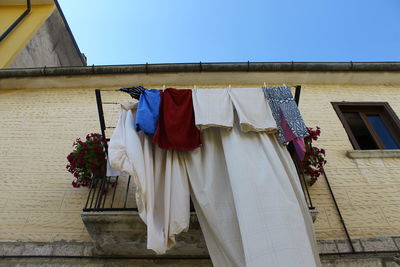 Low angle view of clothes hanging on clothesline against house