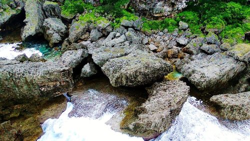 High angle view of stream amidst rocks in river