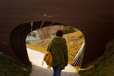 Rear view of woman walking towards tunnel