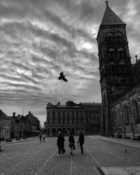 People in front of historical building against sky