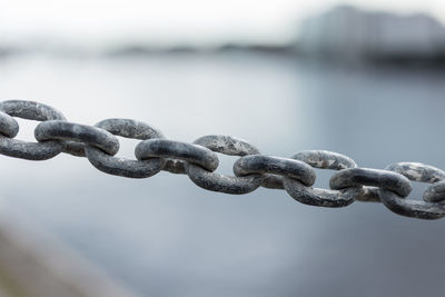 Close-up of chain over lake