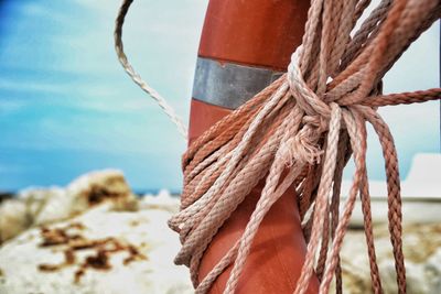 Close-up of rope tied to wooden post in sea