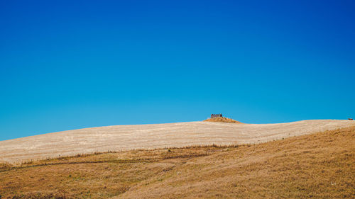 Scenic view of desert against clear blue sky