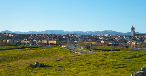 View of buildings in city against clear blue sky