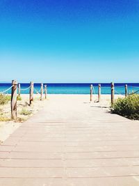 Scenic view of beach against clear blue sky