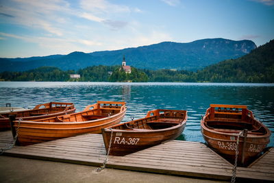 Boats moored on lake against sky