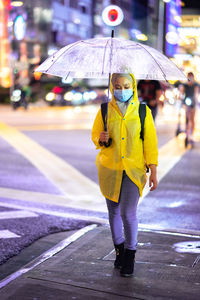 Full length of woman standing on wet street