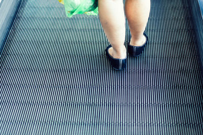 Low section of woman standing on tiled floor