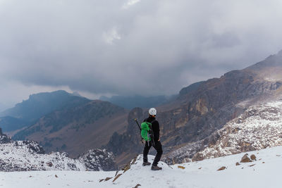 Full length of man standing on snow covered mountain ridge