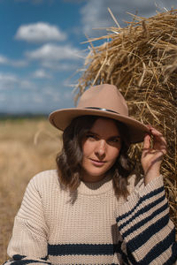 Portrait of young woman wearing hat while standing on land